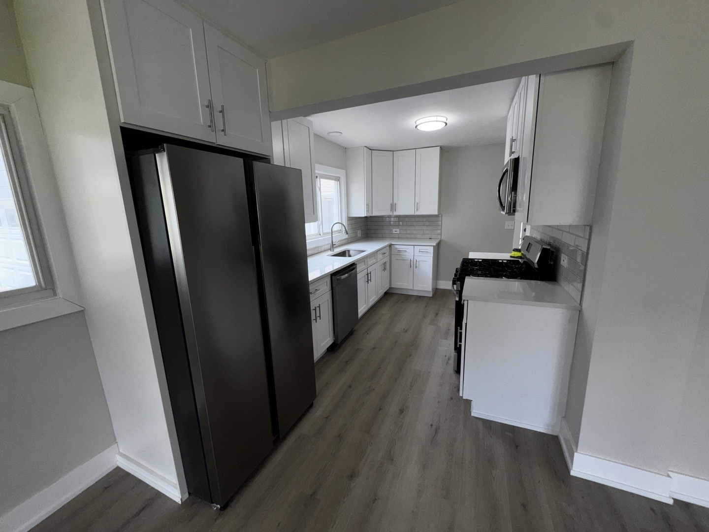 722 East Indiana Street Wheaton, IL 60187 - Photo 6 of 10 a kitchen with a refrigerator a sink and dishwasher a refrigerator with wooden floor