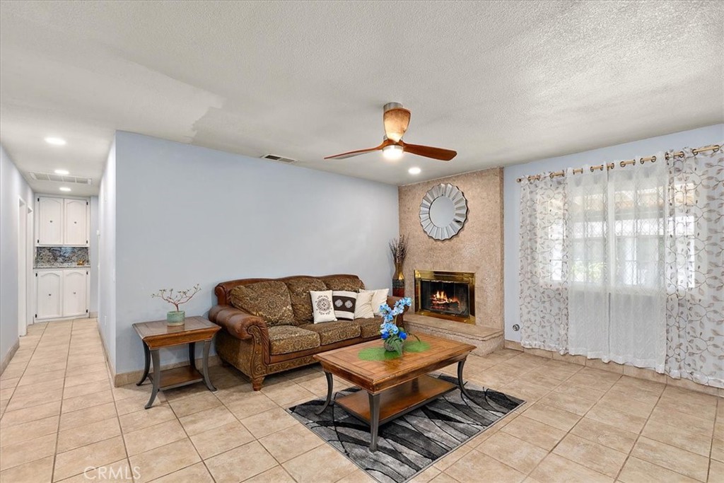 2914 West Wilson Street Banning, CA 92220 - Photo 11 of 31 a living room with furniture a fireplace and a window