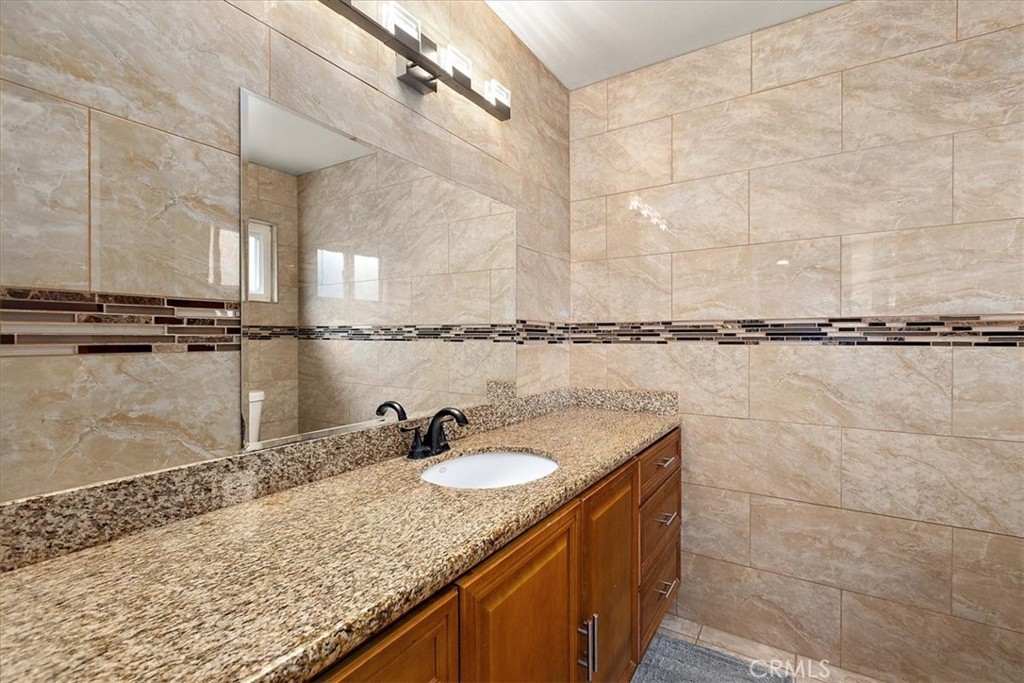 2914 West Wilson Street Banning, CA 92220 - Photo 20 of 31 a bathroom with a granite countertop sink and a mirror