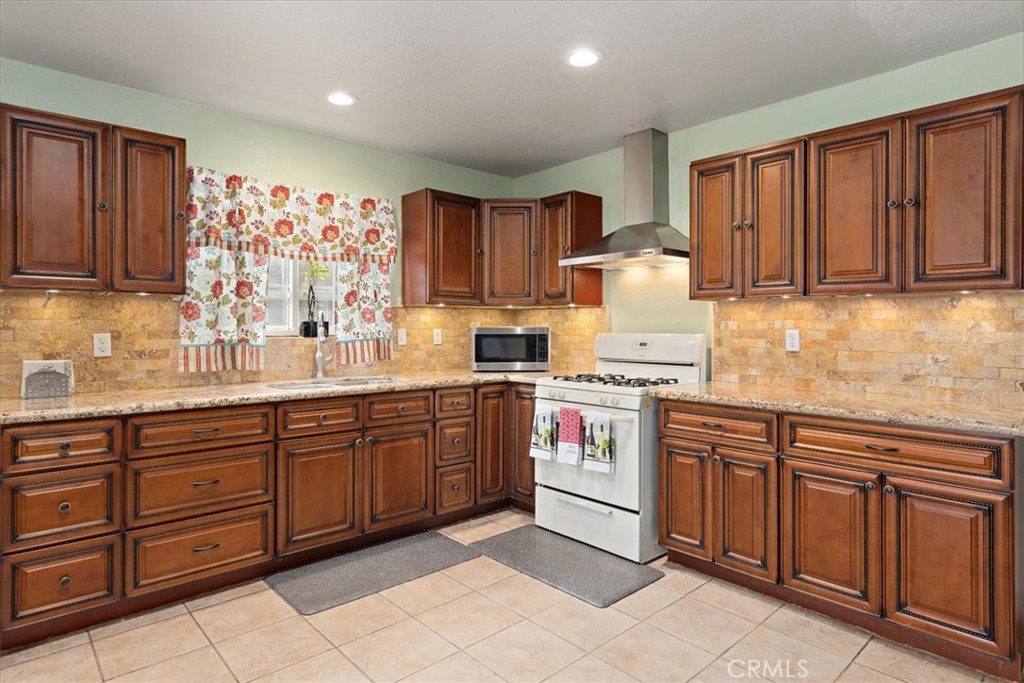 2914 West Wilson Street Banning, CA 92220 - Photo 3 of 31 a kitchen with stainless steel appliances granite countertop a stove sink and cabinets