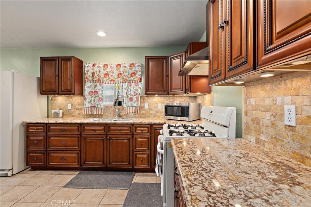 2914 West Wilson Street Banning, CA 92220 - Photo 4 of 31 a kitchen with stainless steel appliances kitchen island granite countertop a sink and cabinets