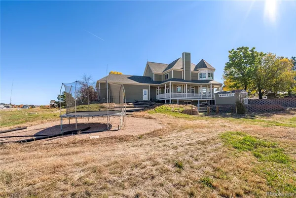 a view of a house with a yard and sitting area
