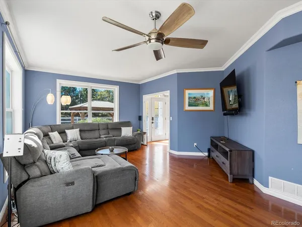 a living room with furniture and a wooden floor
