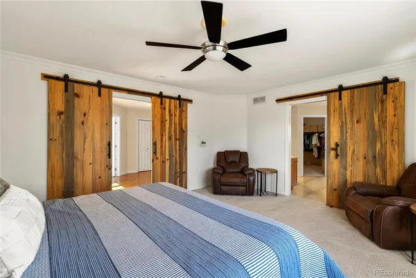 a bedroom with a bed and dresser with wooden floor