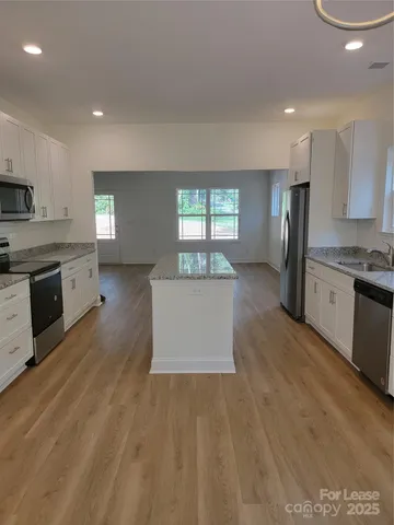a kitchen with stainless steel appliances granite countertop a refrigerator sink and stove