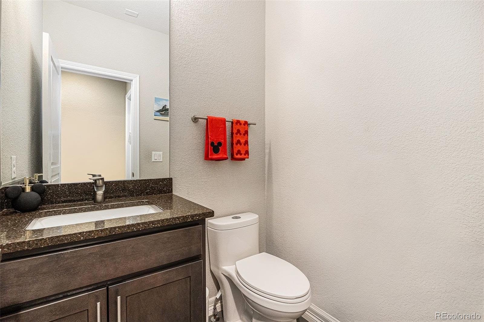 529 Uinta Way Denver, CO 80230 - Photo 13 of 37 a bathroom with a granite countertop toilet sink and mirror