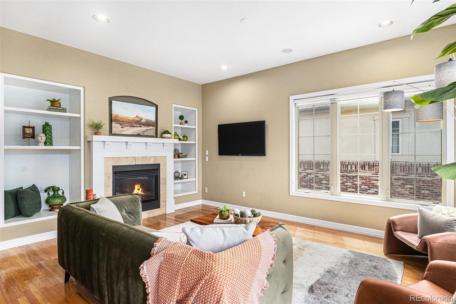529 Uinta Way Denver, CO 80230 - Photo 3 of 37 a living room with furniture a flat screen tv and a fireplace