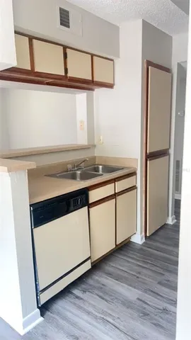 a kitchen with granite countertop white cabinets and wooden floor