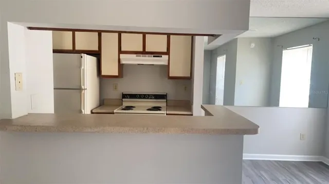 a kitchen with kitchen island a sink and a refrigerator