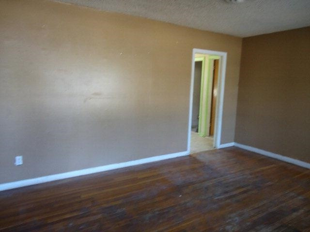 206 16th Street Levelland, TX 79336 - Photo 2 of 8 a view of an empty room with wooden floor and a window