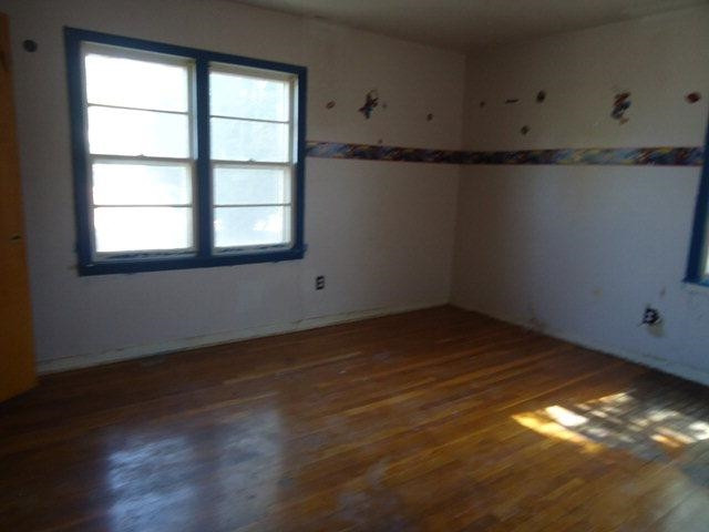 206 16th Street Levelland, TX 79336 - Photo 6 of 8 a view of an empty room with wooden floor and a window