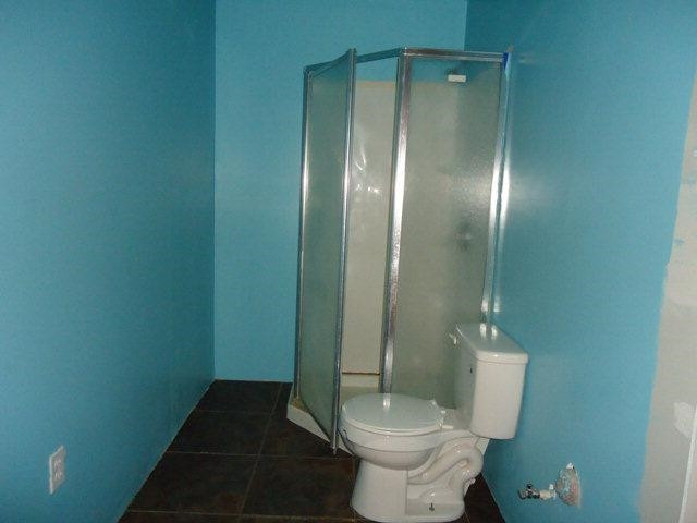 206 16th Street Levelland, TX 79336 - Photo 7 of 8 a bathroom with a toilet and a shower
