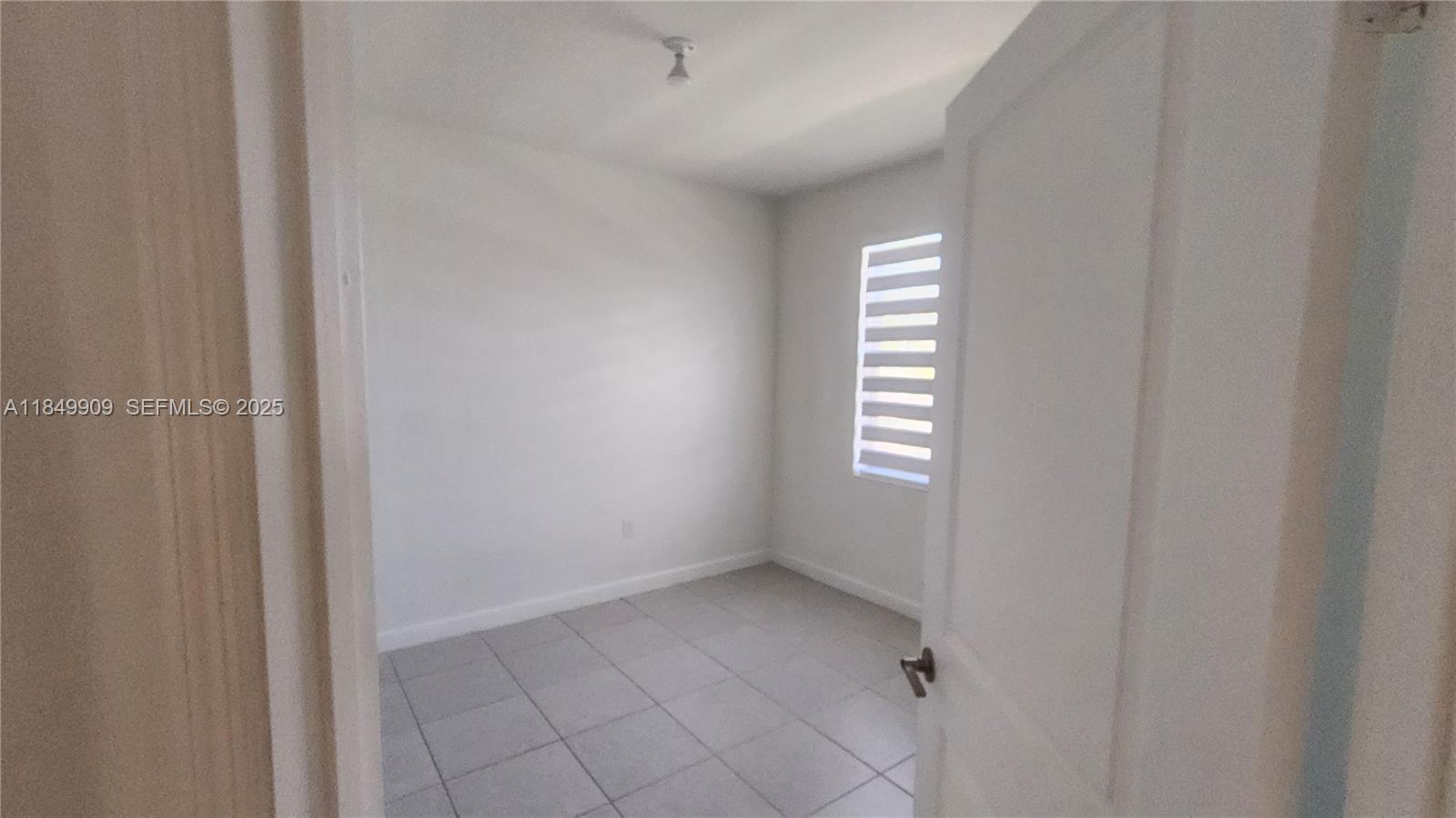 12897 Southwest 234th Street, Unit 12897 Homestead, FL 33032 - Photo 16 of 24 a view of an empty room with a window
