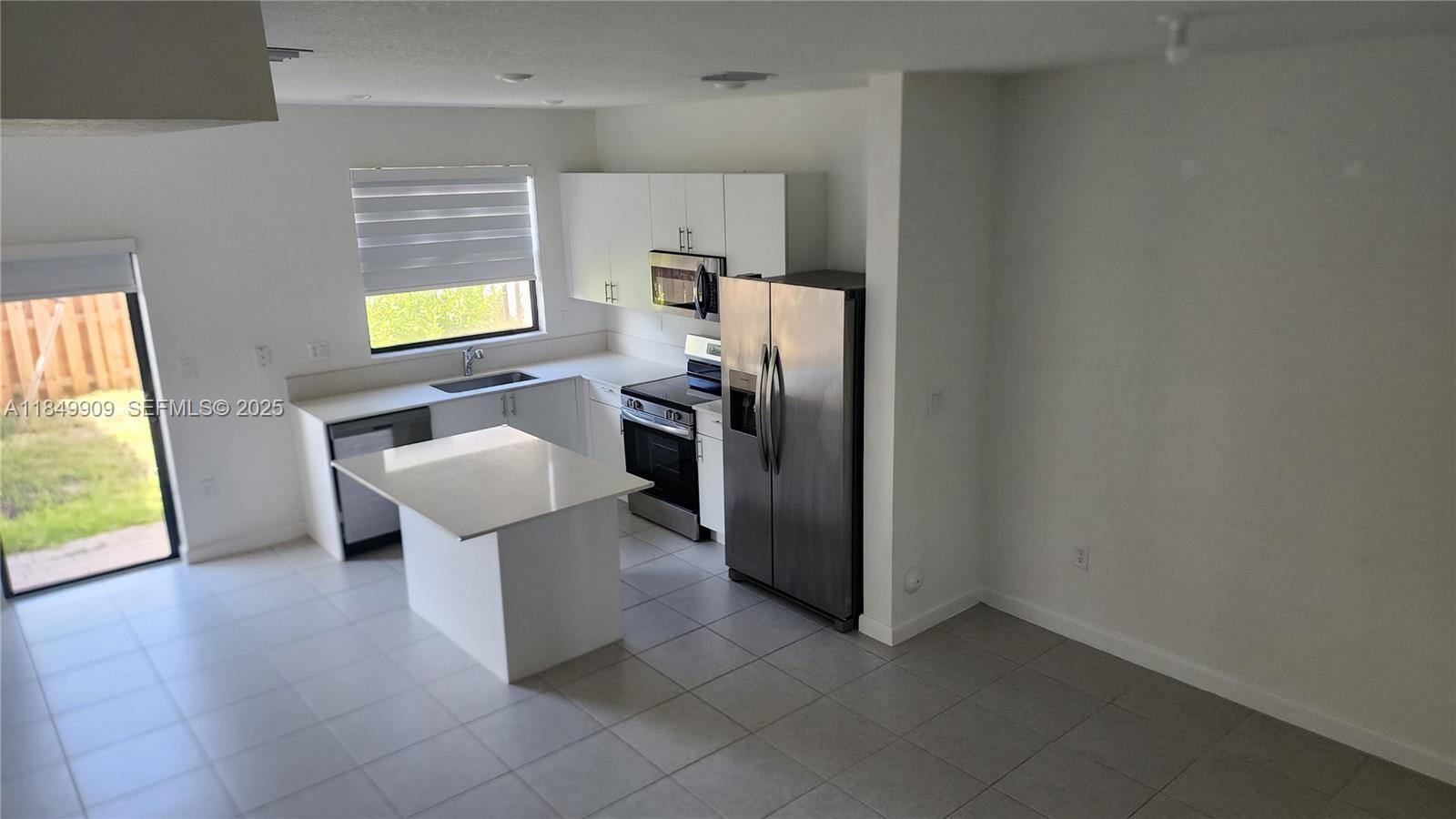 12897 Southwest 234th Street, Unit 12897 Homestead, FL 33032 - Photo 20 of 24 a kitchen with stainless steel appliances a refrigerator and a sink