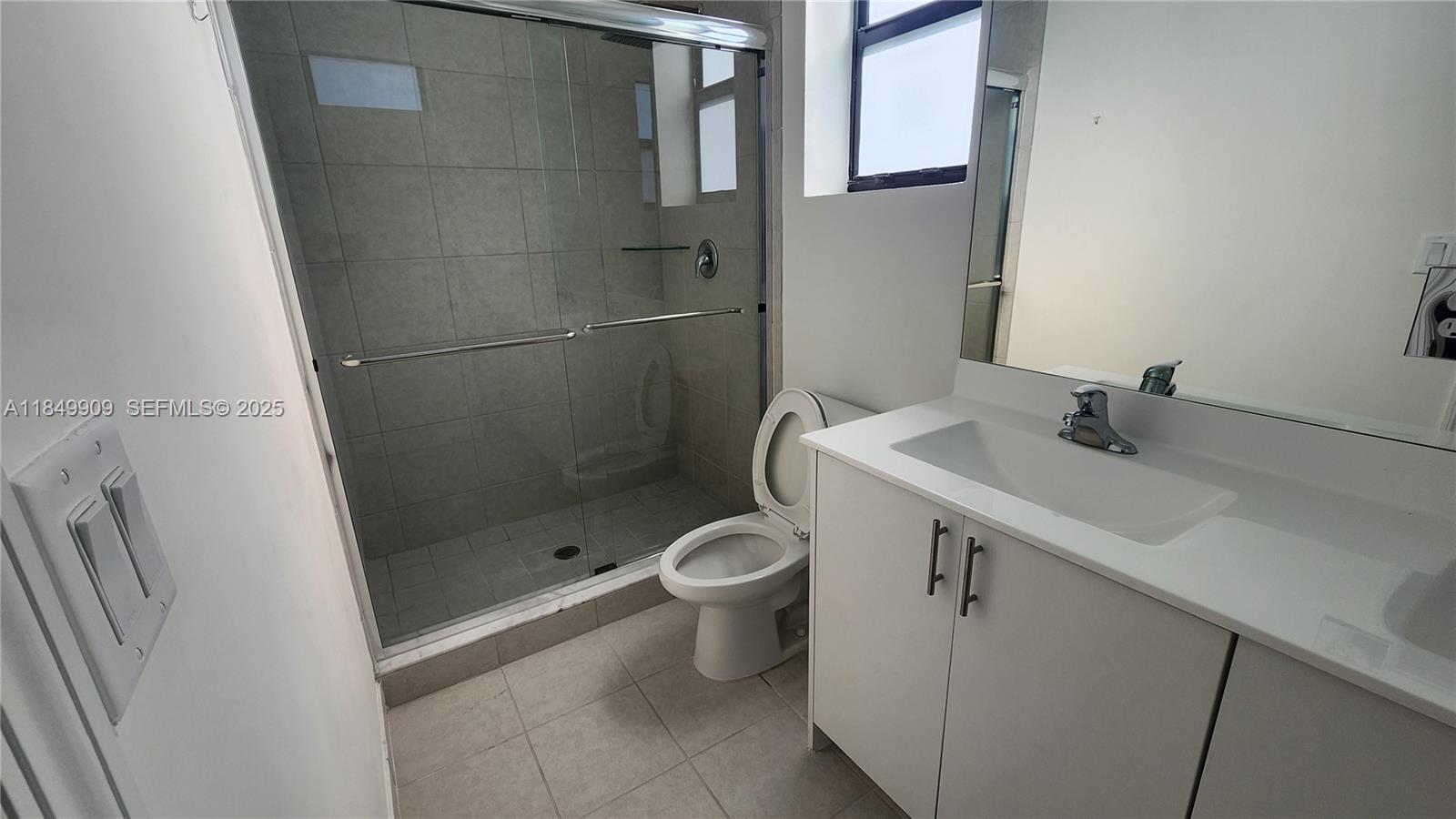 12897 Southwest 234th Street, Unit 12897 Homestead, FL 33032 - Photo 23 of 24 a bathroom with a sink toilet and shower