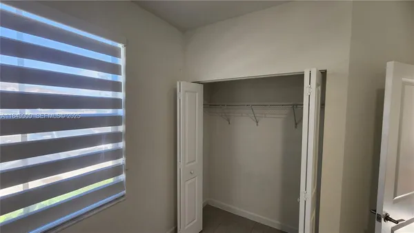 a view of walk in closet with empty racks