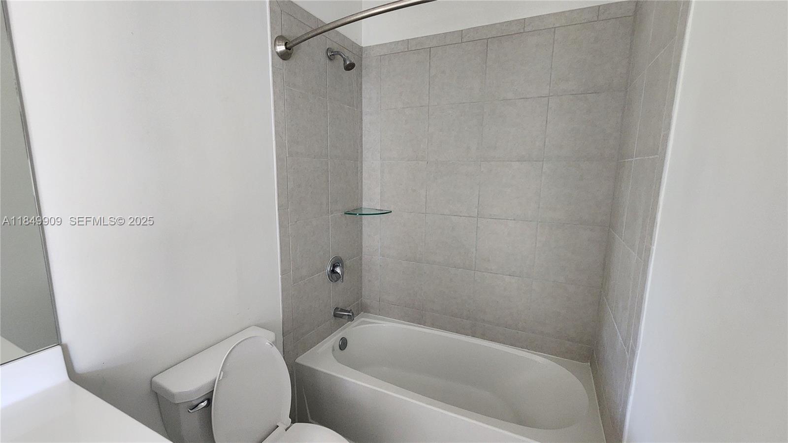 12897 Southwest 234th Street, Unit 12897 Homestead, FL 33032 - Photo 4 of 24 a bathroom with a bathtub and a toilet