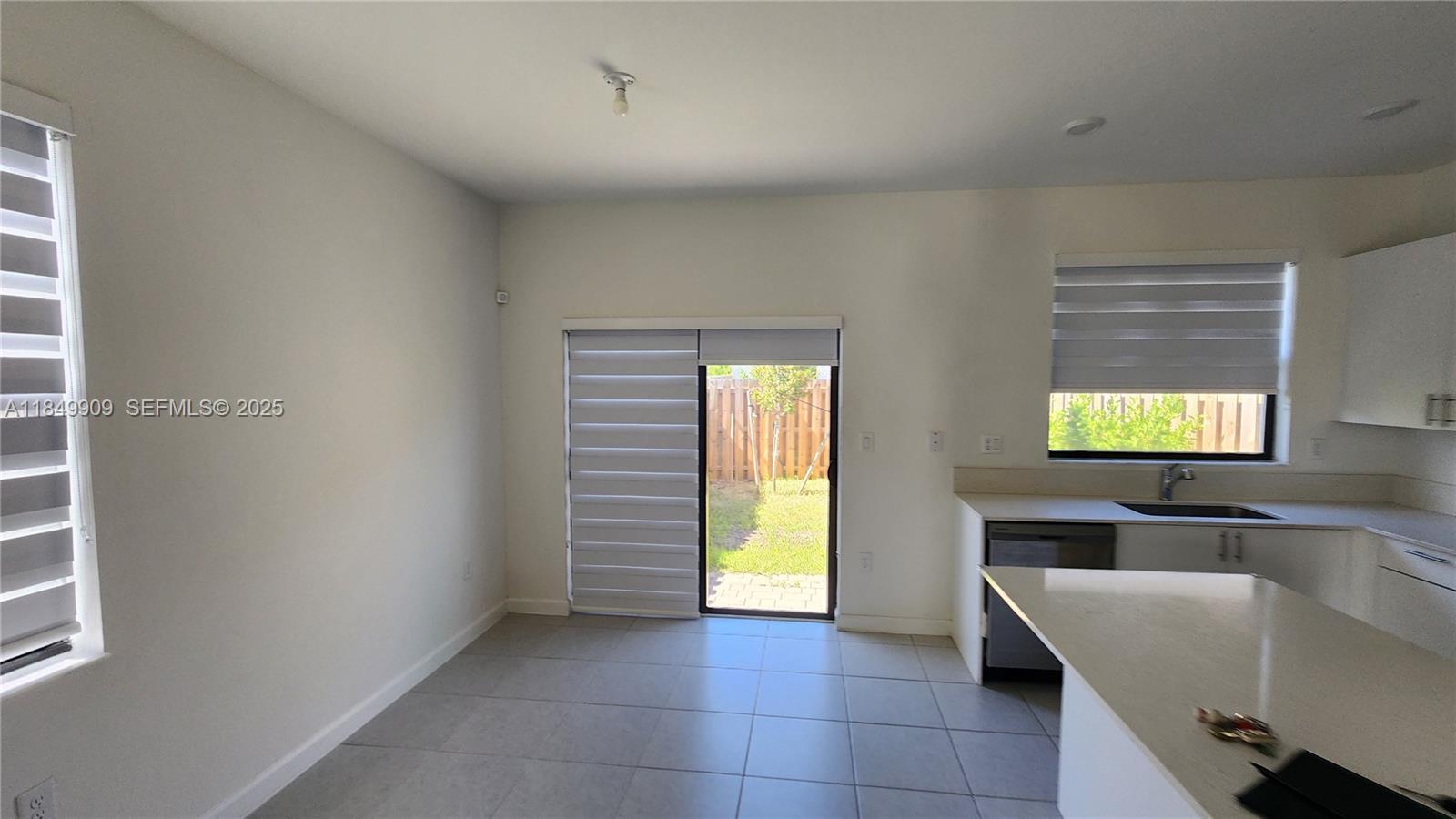 12897 Southwest 234th Street, Unit 12897 Homestead, FL 33032 - Photo 5 of 24 a view of kitchen with windows and refrigerator