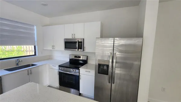 a kitchen with stainless steel appliances a refrigerator a stove a microwave and cabinets