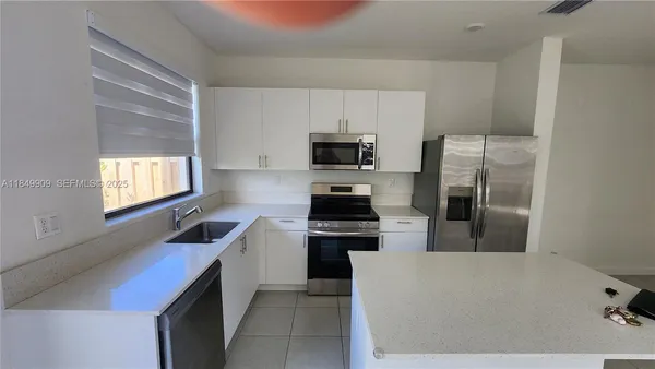 a kitchen with cabinets and steel appliances