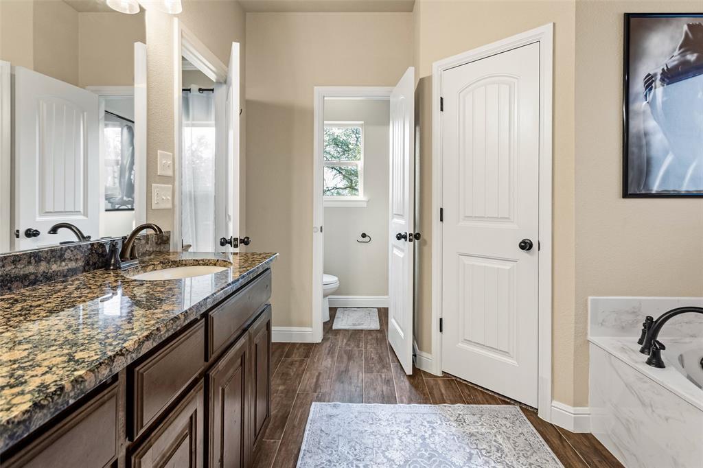 223 Cottongame Road Weatherford, TX 76088 - Photo 19 of 39 a bathroom with a granite countertop sink and a large mirror