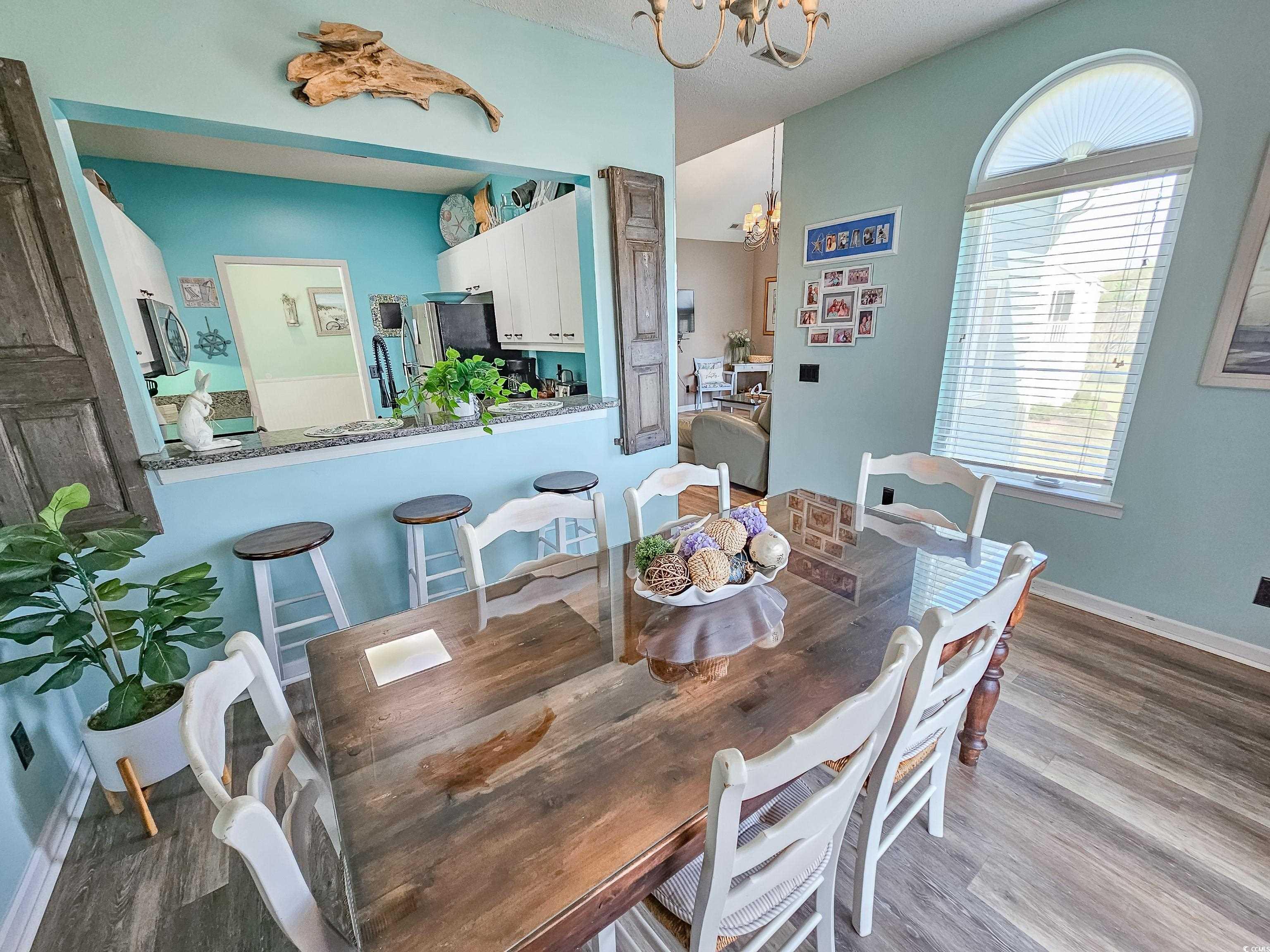 800 Castleford Circle, Unit 1E Myrtle Beach, SC 29572 - Photo 13 of 40 Dining area featuring an inviting chandelier, baseboards, and wood finished floors