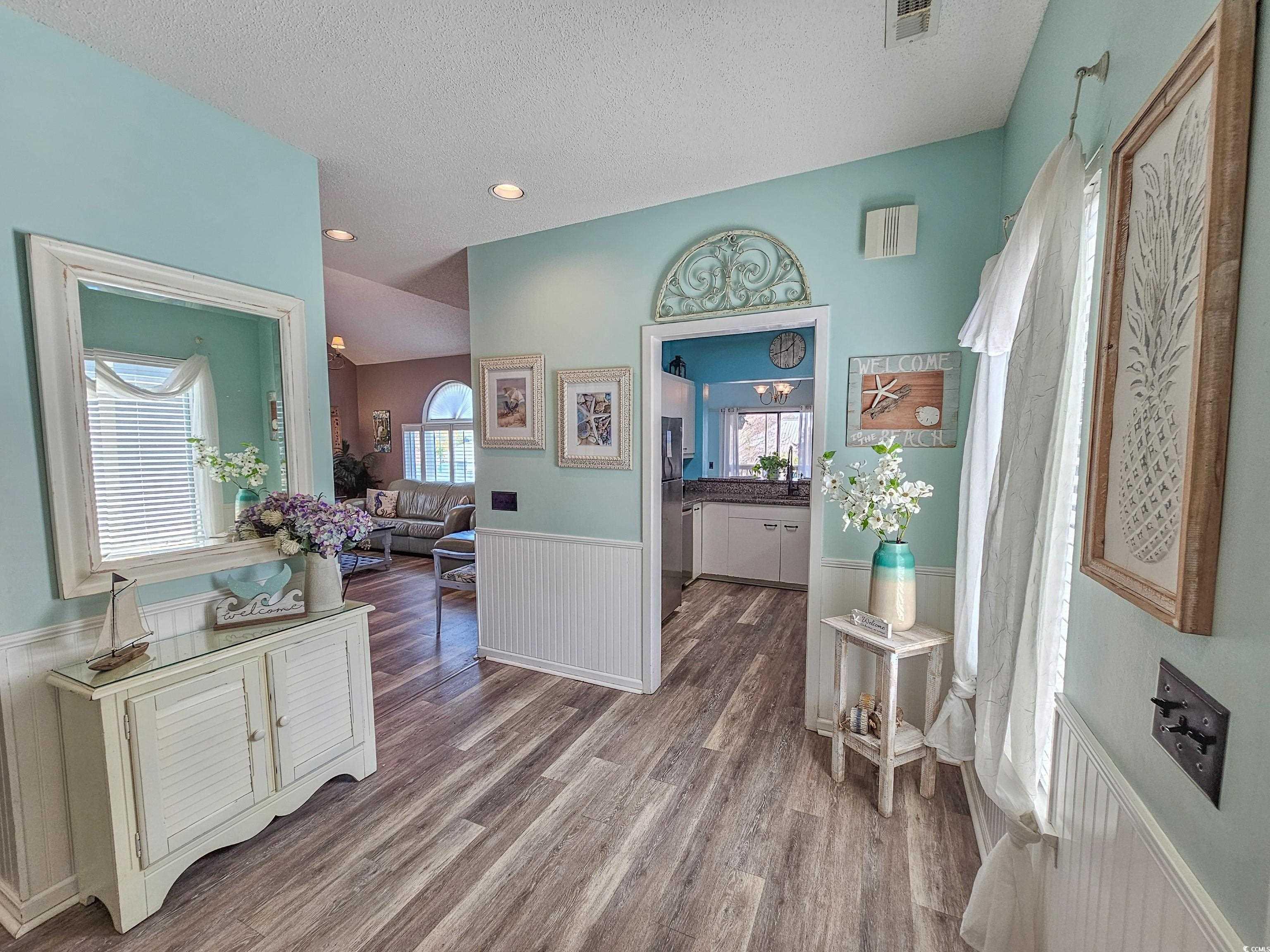 800 Castleford Circle, Unit 1E Myrtle Beach, SC 29572 - Photo 16 of 40 Hall featuring wainscoting, visible vents, wood finished floors, and a textured ceiling