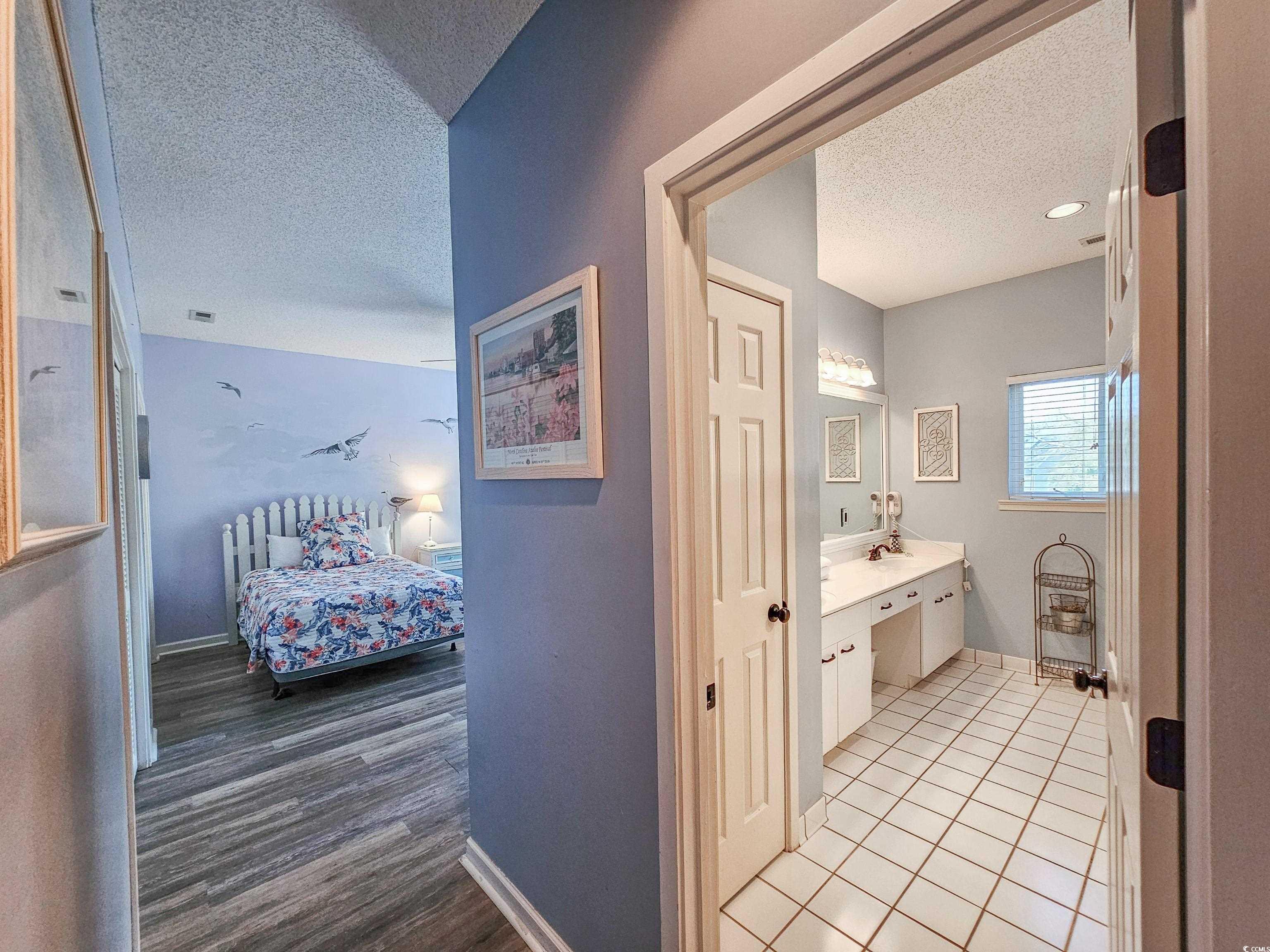 800 Castleford Circle, Unit 1E Myrtle Beach, SC 29572 - Photo 20 of 40 Ensuite bathroom with connected bathroom, baseboards, vanity, and a textured ceiling