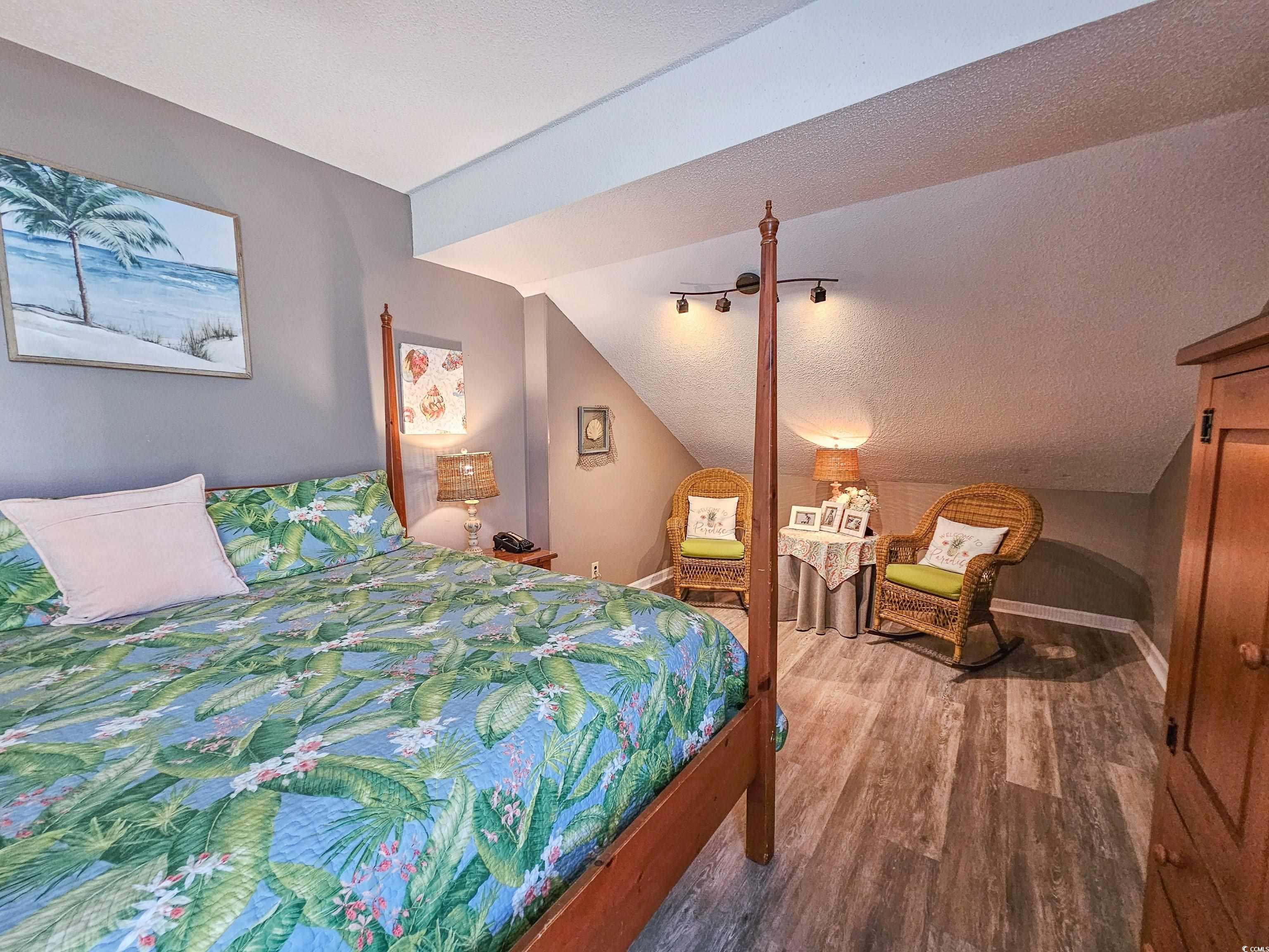 800 Castleford Circle, Unit 1E Myrtle Beach, SC 29572 - Photo 28 of 40 Bedroom with baseboards, a textured ceiling, lofted ceiling, and wood finished floors