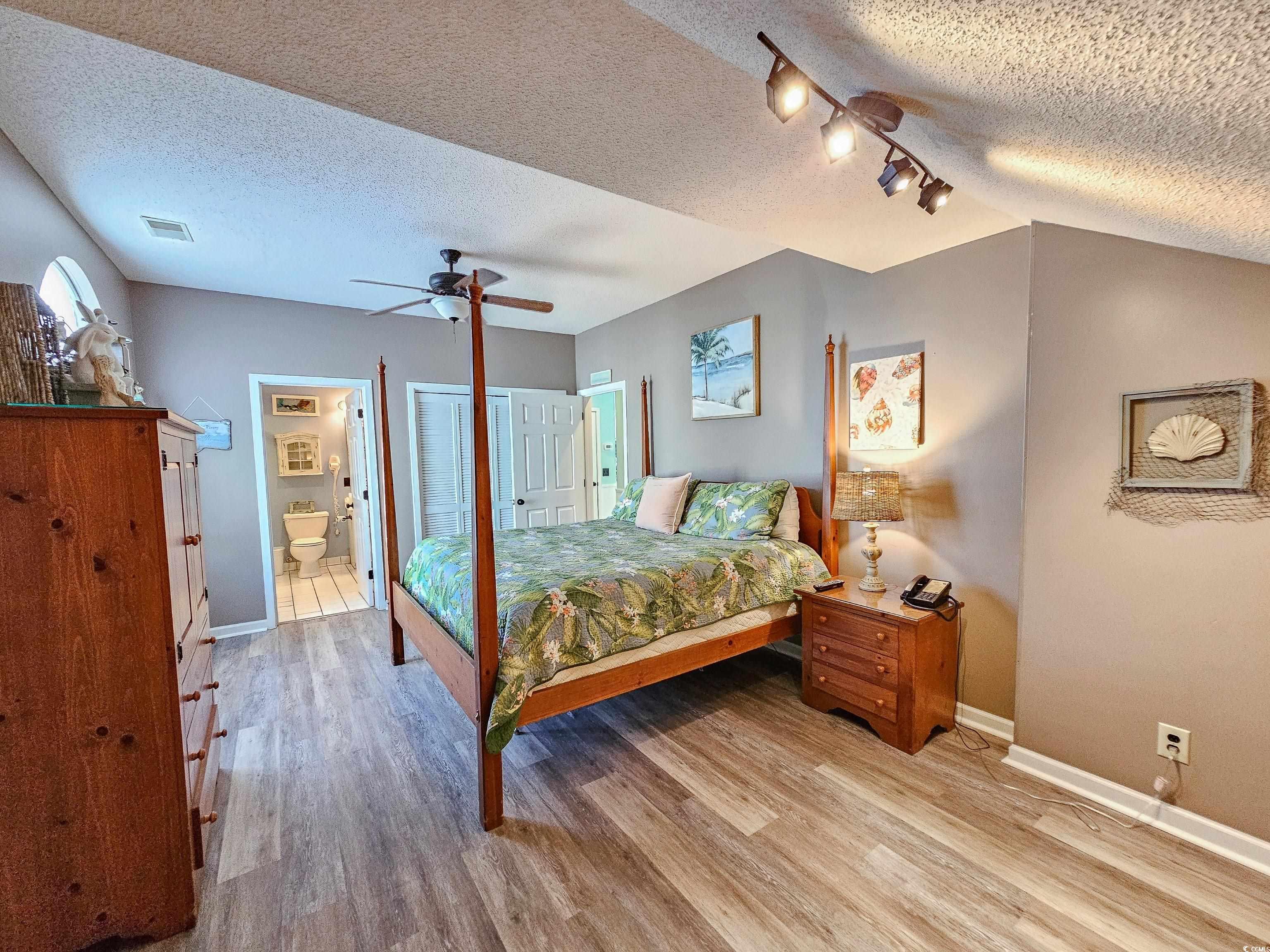 800 Castleford Circle, Unit 1E Myrtle Beach, SC 29572 - Photo 29 of 40 Bedroom featuring a textured ceiling, baseboards, and wood finished floors