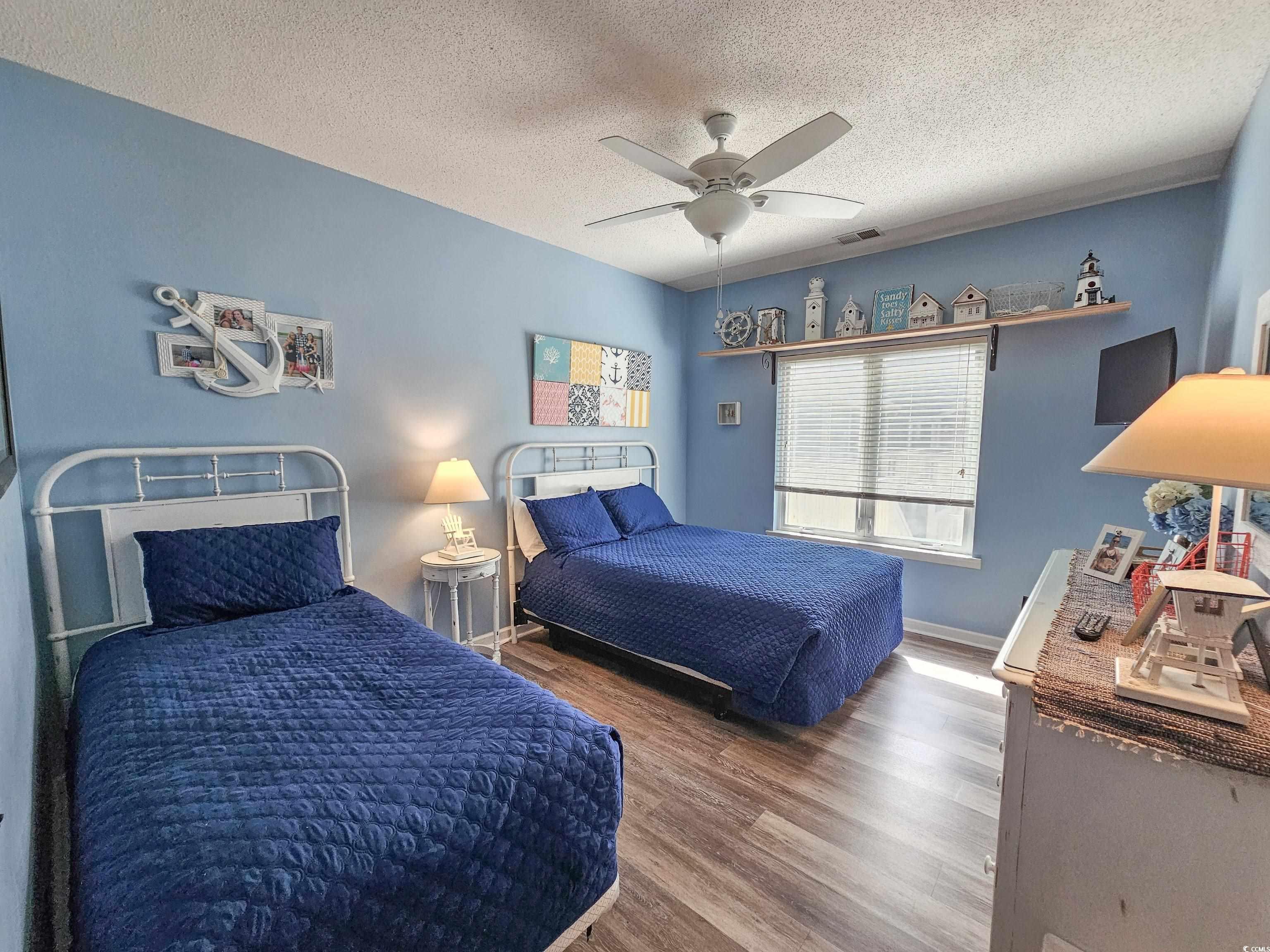 800 Castleford Circle, Unit 1E Myrtle Beach, SC 29572 - Photo 32 of 40 Bedroom featuring visible vents, wood finished floors, ceiling fan, and a textured ceiling