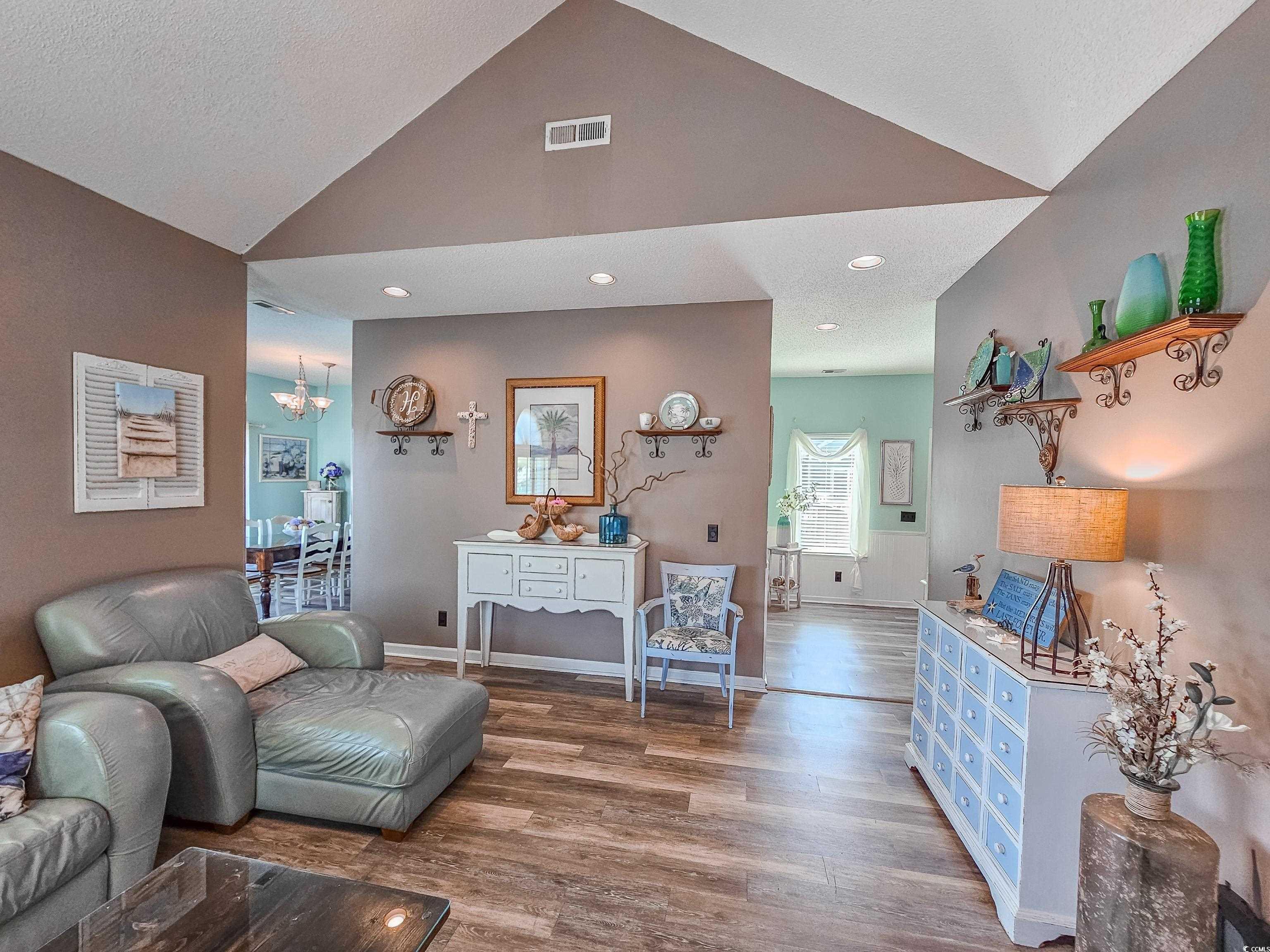 800 Castleford Circle, Unit 1E Myrtle Beach, SC 29572 - Photo 5 of 40 Living area featuring baseboards, visible vents, wood finished floors, and vaulted ceiling
