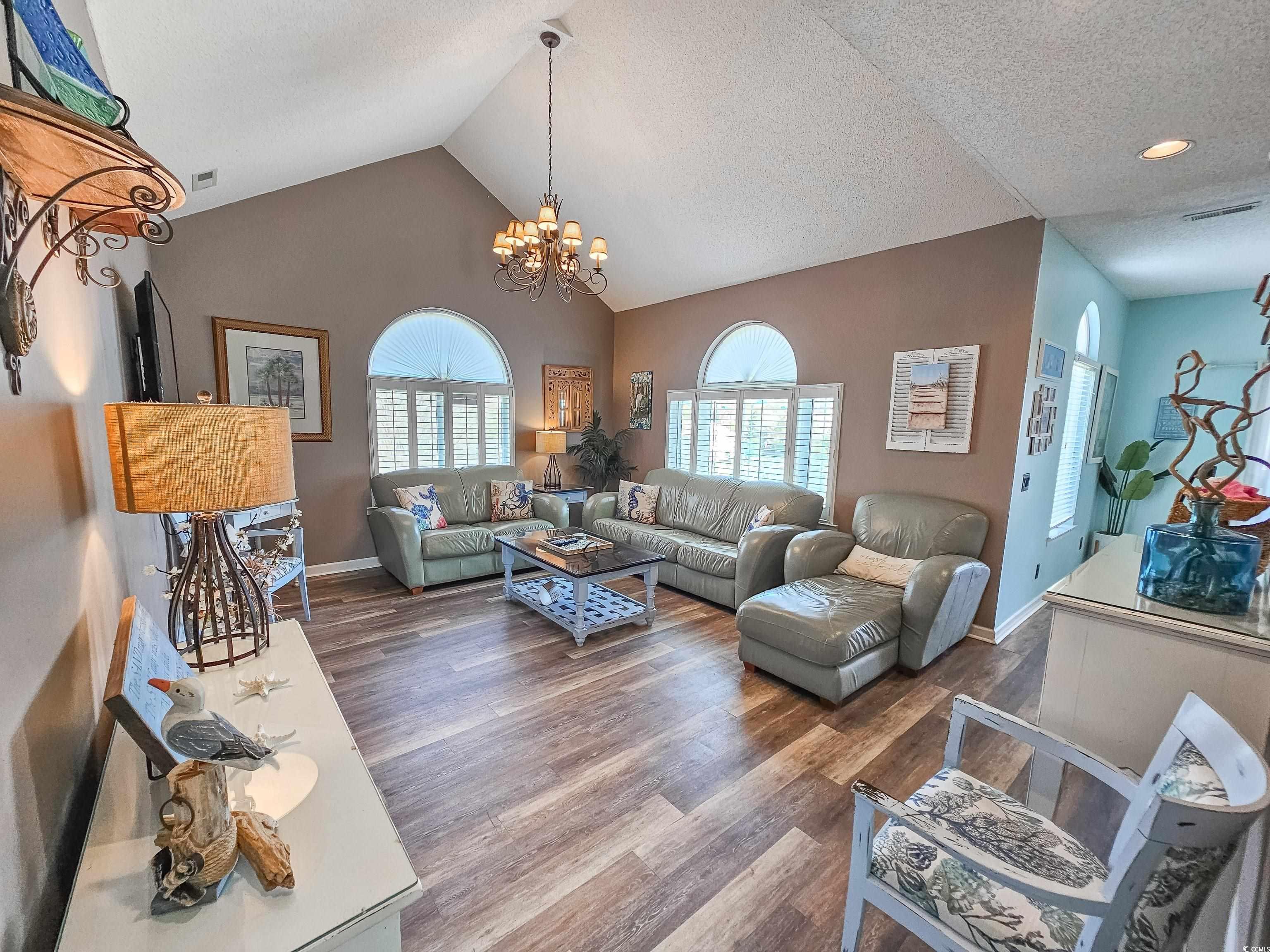 800 Castleford Circle, Unit 1E Myrtle Beach, SC 29572 - Photo 7 of 40 Living area with plenty of natural light, a chandelier, and wood finished floors