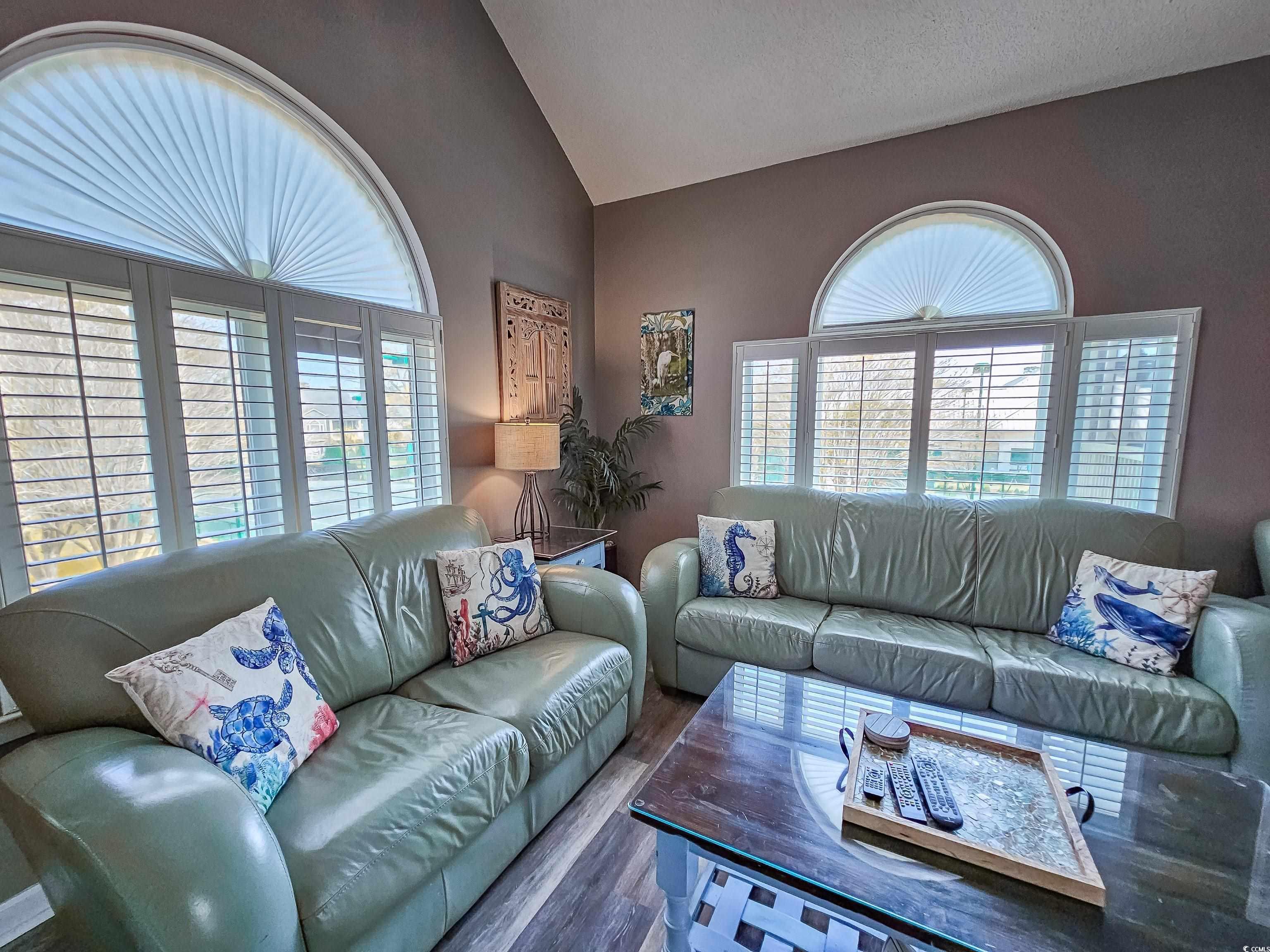 800 Castleford Circle, Unit 1E Myrtle Beach, SC 29572 - Photo 8 of 40 Living room with a healthy amount of sunlight, vaulted ceiling, and wood finished floors