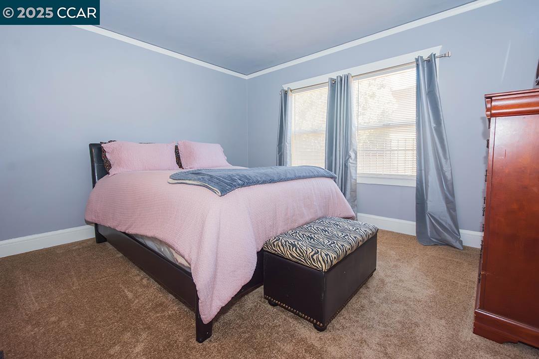 Melrose Heights Oakland, CA 94621 - Photo 12 of 34 a bedroom with a bed lamp and a window