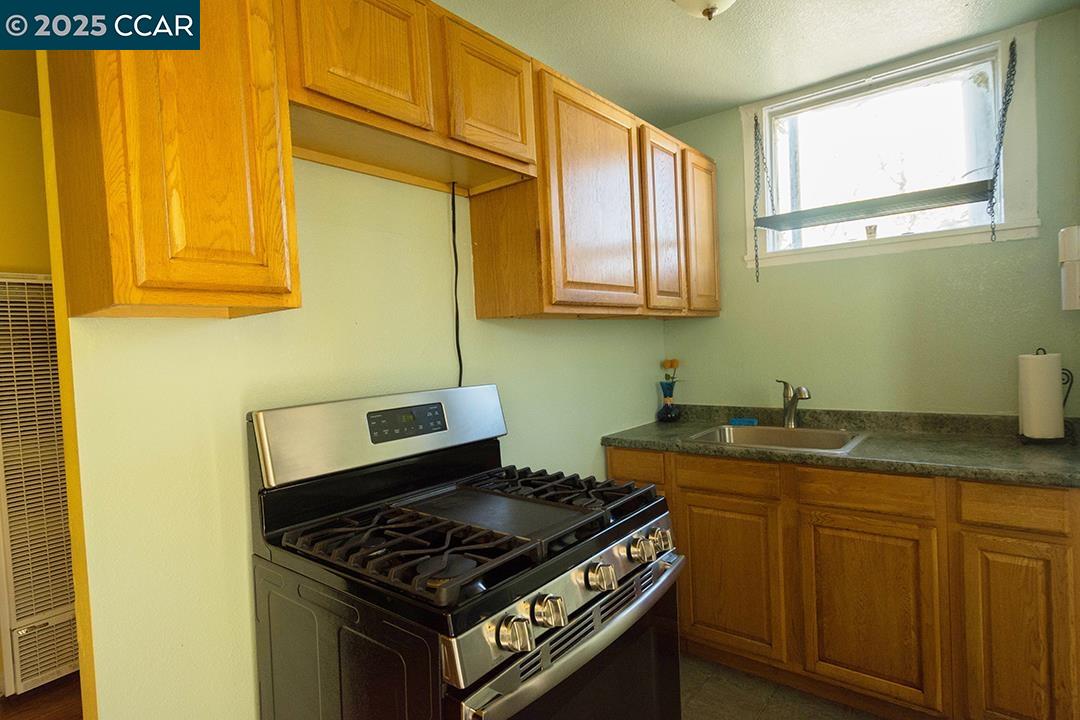 Melrose Heights Oakland, CA 94621 - Photo 30 of 34 a kitchen with granite countertop cabinets stove and sink