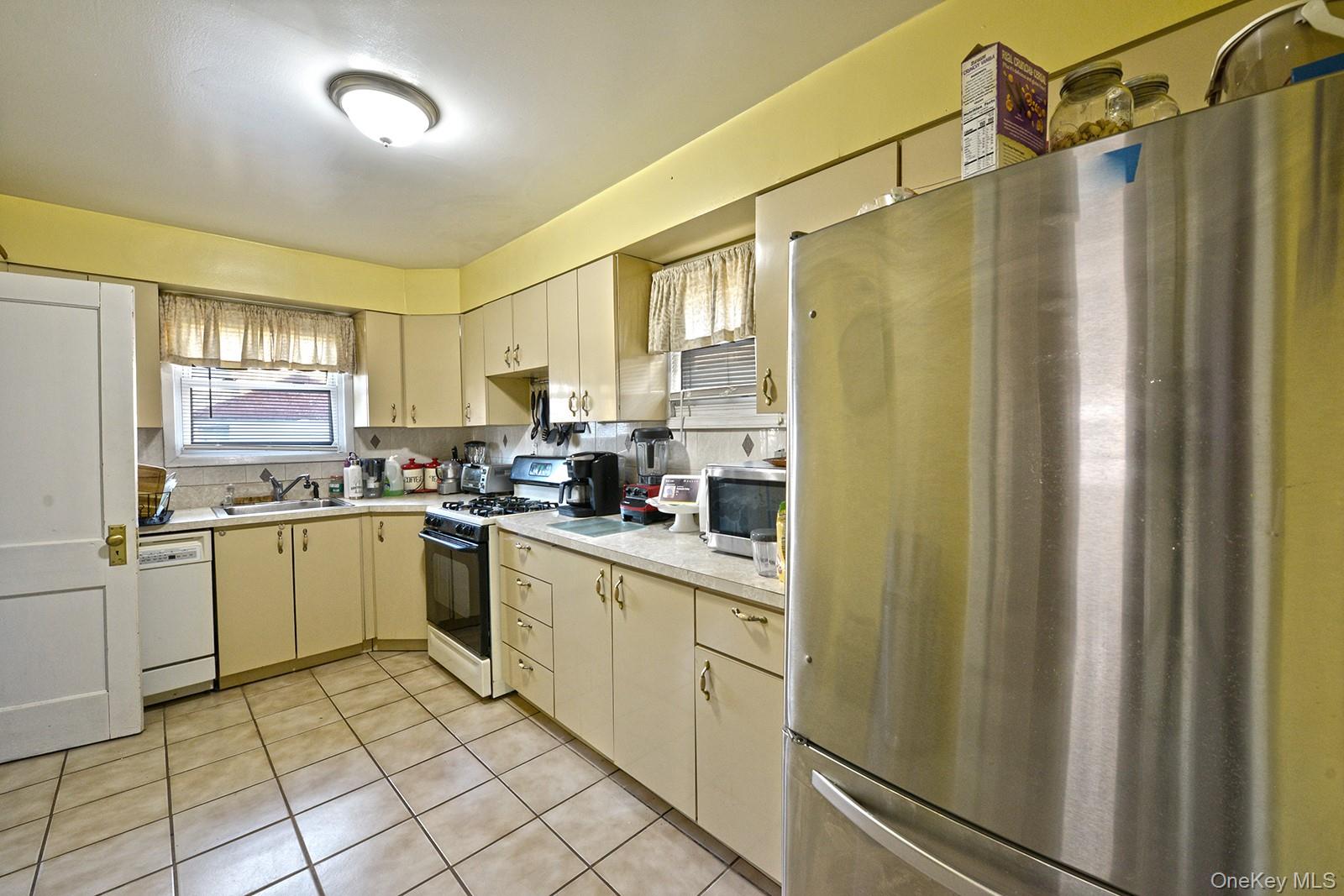 92-49 Springfield Boulevard Queens, NY 11428 - Photo 7 of 17 a kitchen with a refrigerator a sink and dishwasher