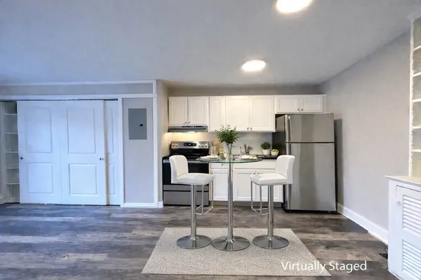 a living room with furniture a refrigerator and kitchen view