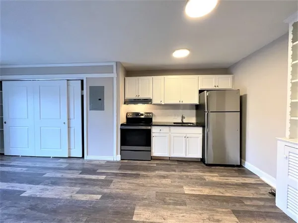 a kitchen with a refrigerator and a stove top oven
