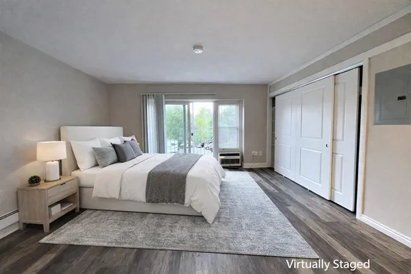 a spacious bedroom with a bed and wooden floor