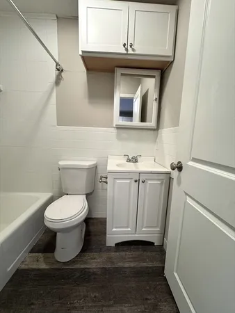 a bathroom with a toilet sink and cabinets