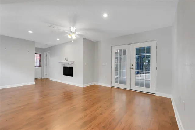 a view of an empty room with a window and wooden floor