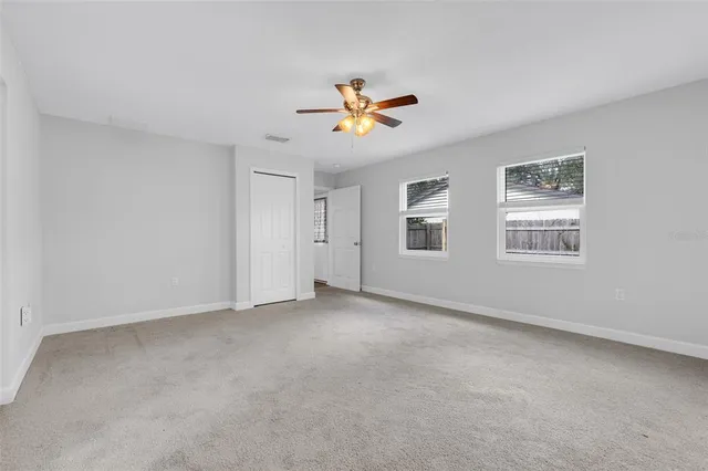 a view of a room with a ceiling fan and a window