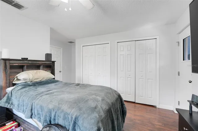 a bedroom with a bed and wooden floor