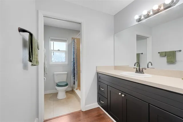 a spacious bathroom with a toilet sink and mirror