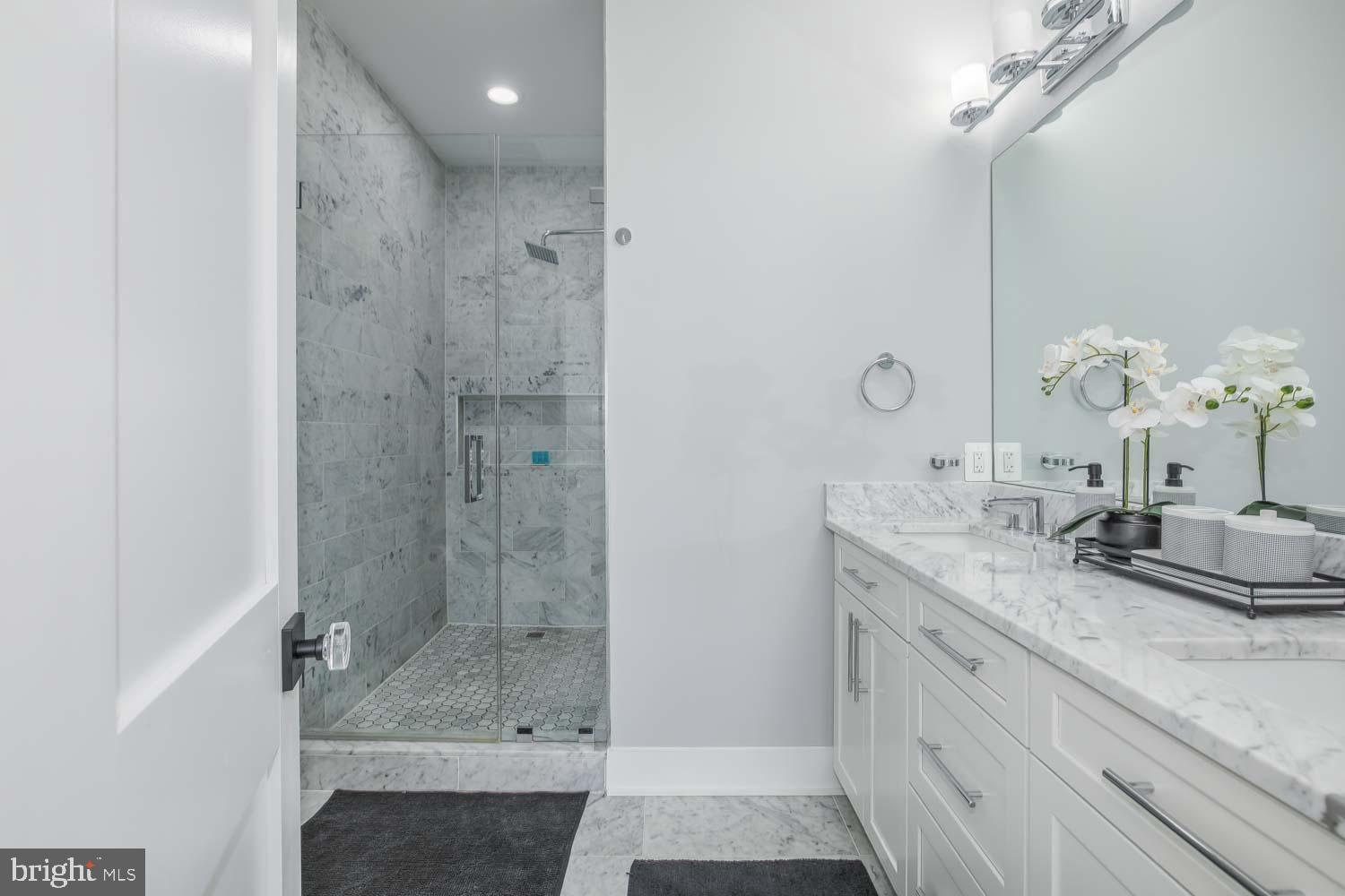 1427 Perry Place Northwest Washington, DC 20010 - Photo 15 of 40 a bathroom with a granite countertop sink a mirror and shower