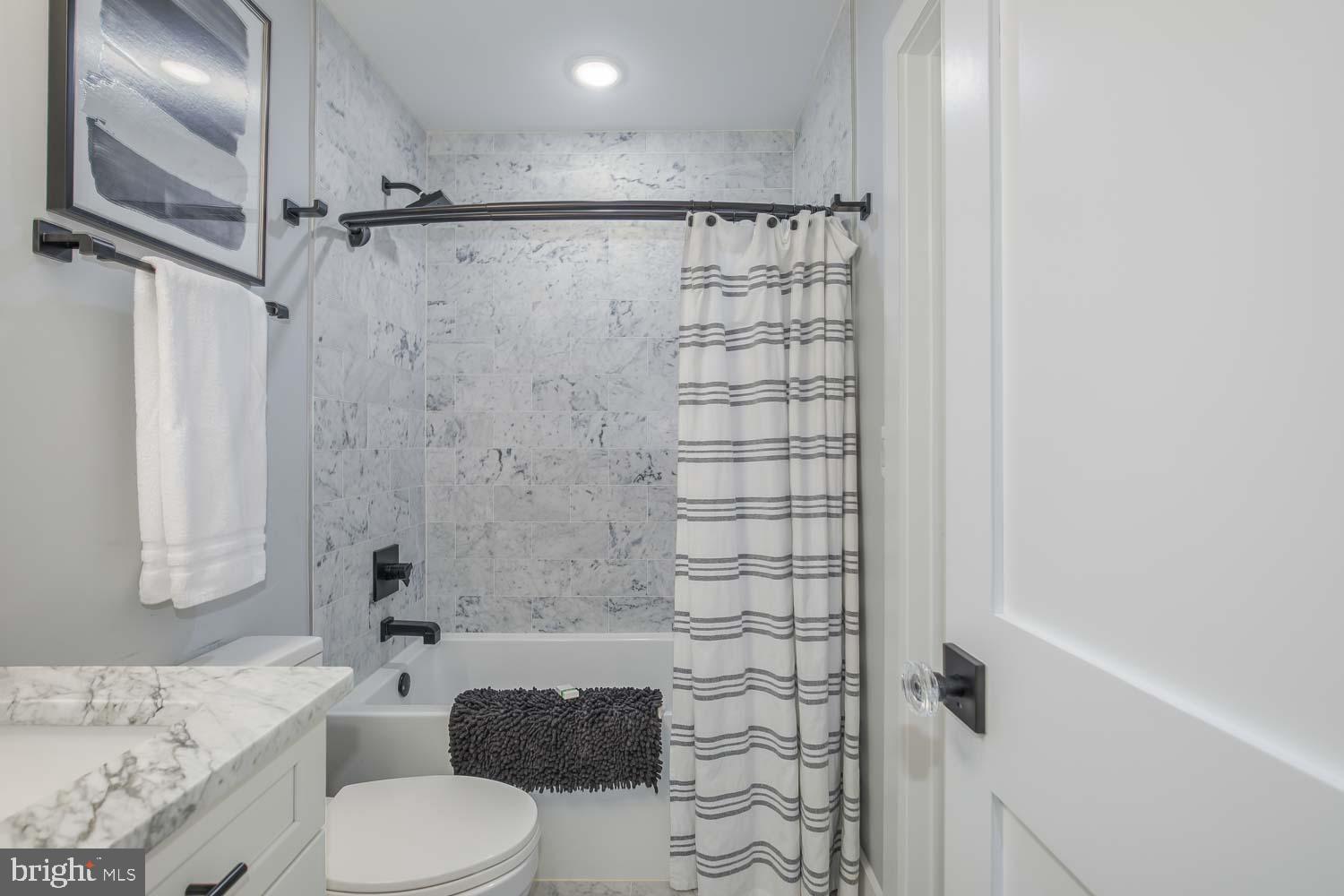 1427 Perry Place Northwest Washington, DC 20010 - Photo 18 of 40 a bathroom with a granite countertop sink a toilet and shower