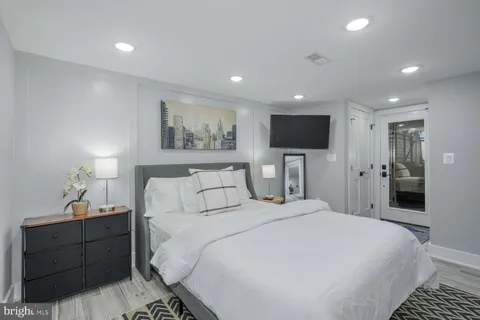 a spacious bedroom with a bed and a flat screen tv