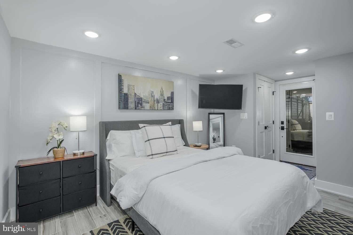 1427 Perry Place Northwest Washington, DC 20010 - Photo 36 of 40 a spacious bedroom with a bed and a flat screen tv