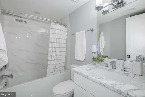 a bathroom with a granite countertop sink toilet and shower